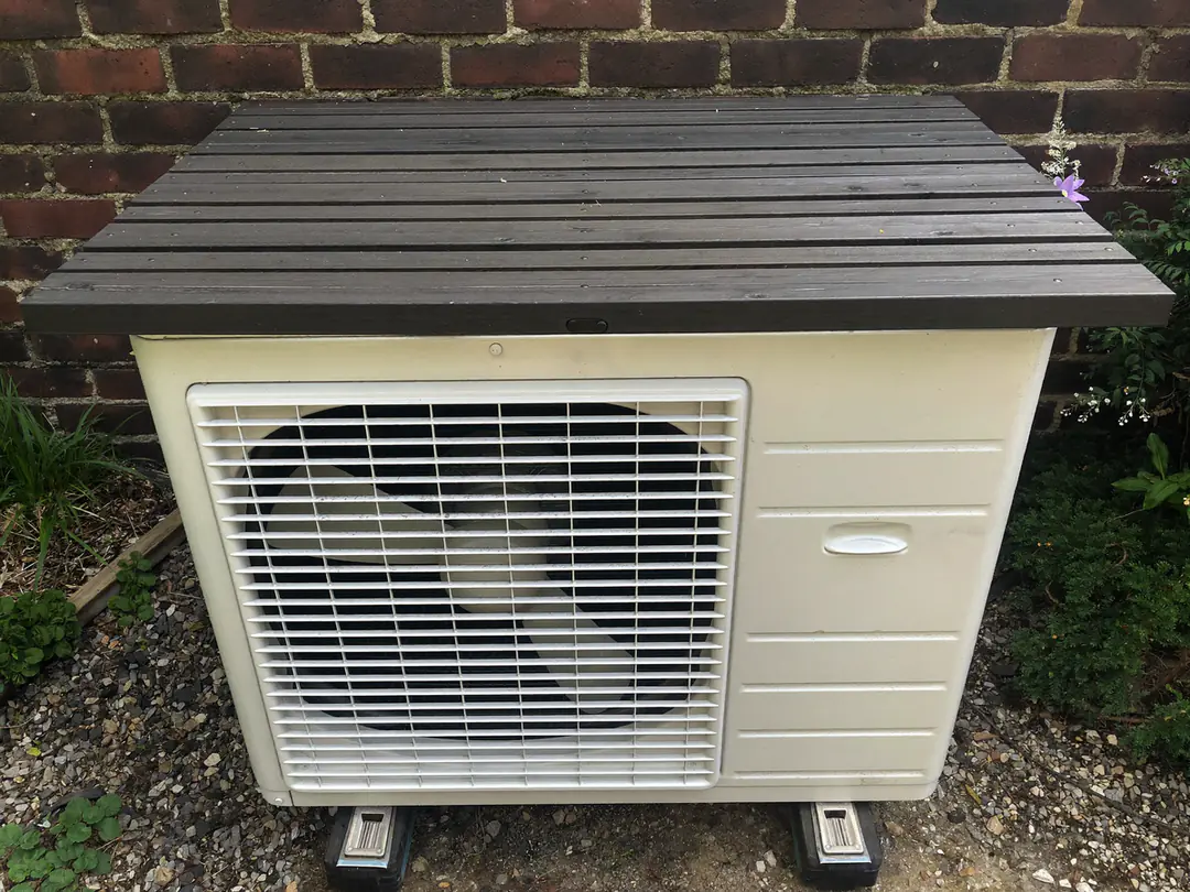 Buitenunit in een tuin met een houten afdekking