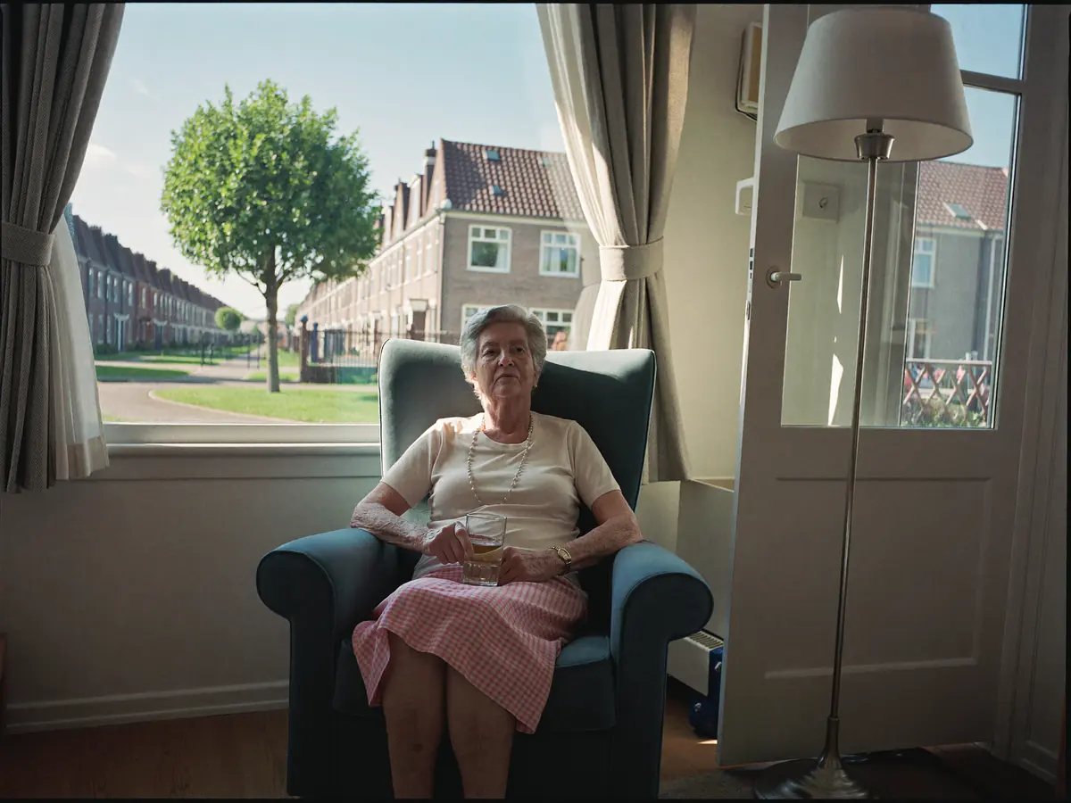 Oudere vrouw met een glas water in een koele woonkamer