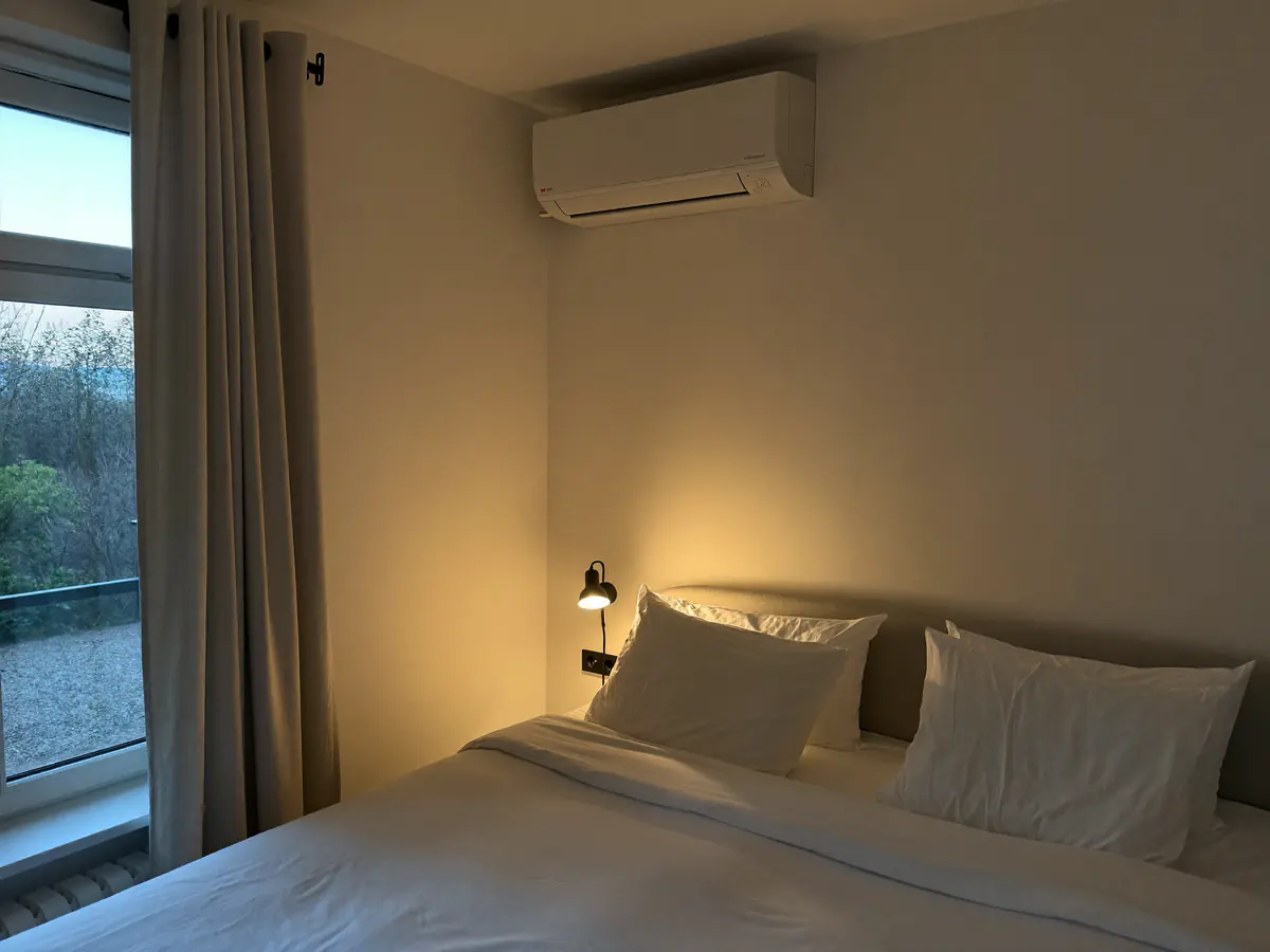 Slaapkamer met een tweepersoonsbed en een binnenunit hoog aan de muur